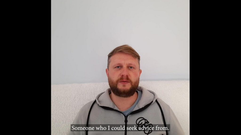 Man on beach wearing grey top
